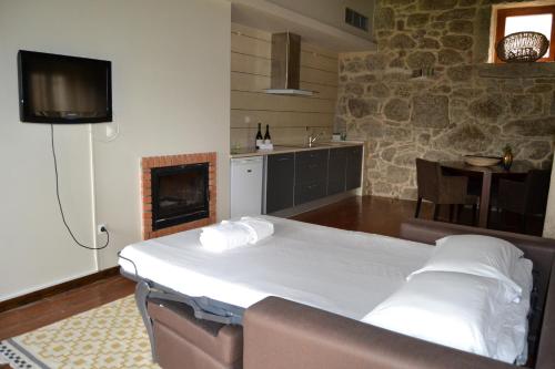 a bedroom with a bed and a tv and a fireplace at Quinta do Medronheiro Hotel Rural in Viseu