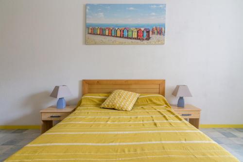 um quarto com uma cama com uma colcha amarela e um quadro em île d’Aix em Rochefort