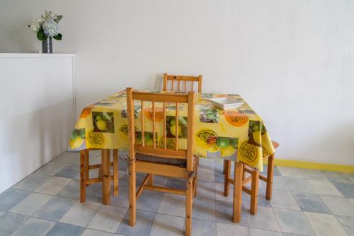 une table à manger avec deux chaises et un tissu de table dans l'établissement île d’Aix, à Rochefort