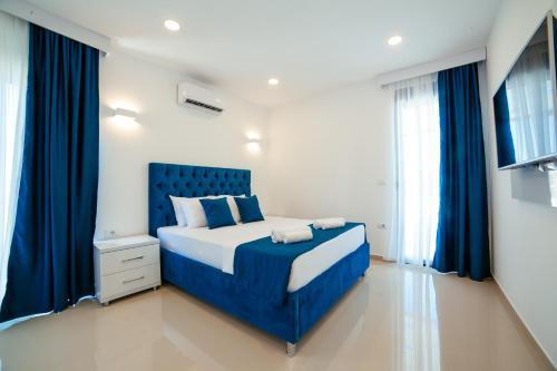 1 dormitorio con cama azul y cortinas azules en Hotel Ambiente Ulcinj, en Ulcinj