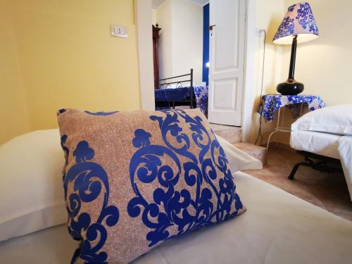 a bedroom with a blue and white pillow on a bed at Del Centro in Enna