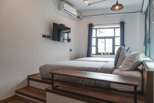 a bedroom with a bed and a window at Chernchan Hostel in Chanthaburi