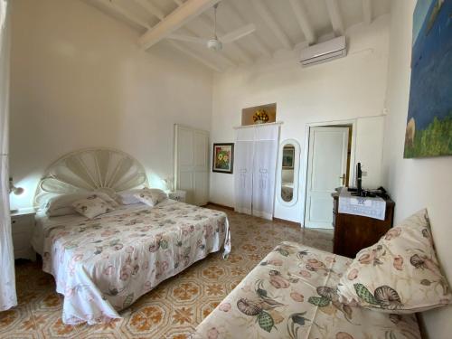 a bedroom with a bed and a couch in it at Basiluzzo Resort in Panarea