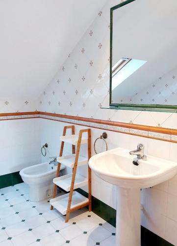 a bathroom with a sink and a toilet and a mirror at Casa Sueño in Foz