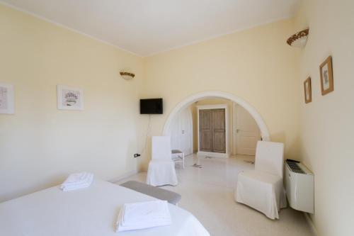 クトロフィアーノにあるParco Degli Aranciの白い椅子2脚とテーブルが備わる白い部屋