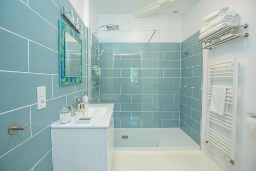 a blue tiled bathroom with a sink and a shower at Domaine de Terrac in Rimont