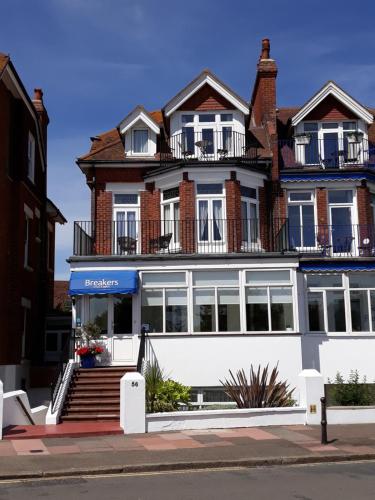 Un grand bâtiment blanc avec des fenêtres donne sur une rue. dans l'établissement Breakers Bed and Breakfast, à Eastbourne