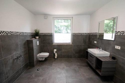 a bathroom with a sink and a toilet and a mirror at Ferienhaus mit Terrasse und Garten in Wandlitz in Wandlitz
