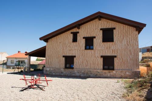 a large building with windows and red poles in front at Casa Rural Consuelo in Torralba