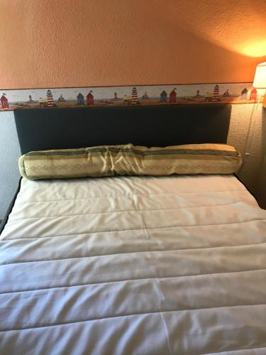 a white bed with a head board and shelves on the wall at Les balcons de la Medtirrannée front de mer in Narbonne-Plage