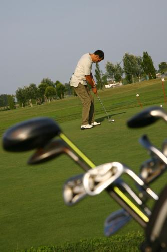a man is playing golf on a golf course at Hotel Helios in Lido di Jesolo
