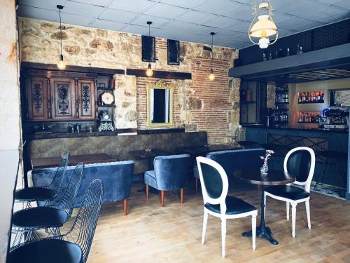 un bar con sedie e tavoli in una stanza di L'Entrée Chambres d'Hôtes Bar & Restaurant a Castillonnès