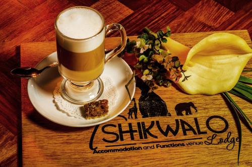 a book with a cup of coffee and a plate of food at Tshikwalo Game Lodge in Klipdrift