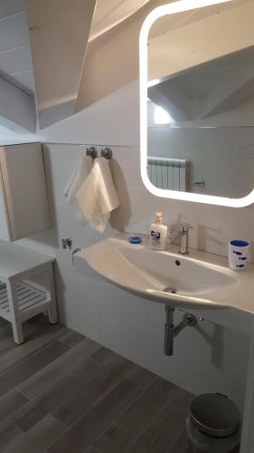 a white bathroom with a sink and a mirror at Orchidea Rooms & Suites in Civitanova Marche