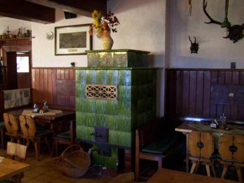 a dining room with a table and a green fireplace at Penzion Štekrův Mlýn in Františkovy Lázně