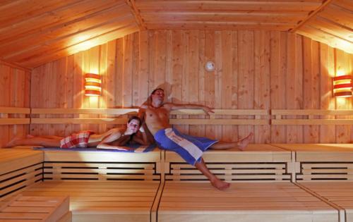 two people are laying in a sauna at Appartement Fritzenwallner in Wagrain