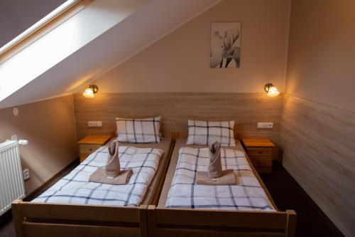 a attic bedroom with two beds with towels on them at Penzion Štekrův Mlýn in Františkovy Lázně