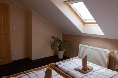 a attic bedroom with two beds and a skylight at Penzion Štekrův Mlýn in Františkovy Lázně
