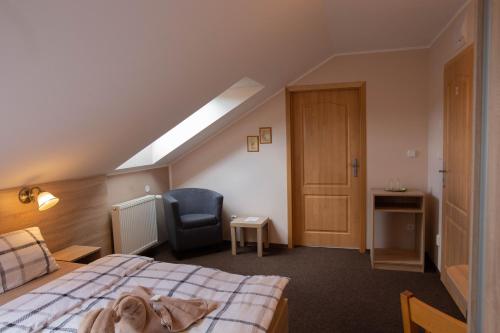 a bedroom with a bed and a chair and a window at Penzion Štekrův Mlýn in Františkovy Lázně