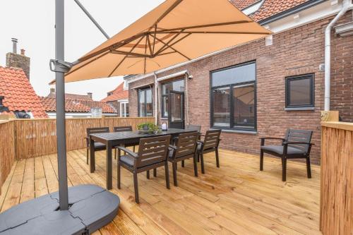 a patio with a table and chairs and an umbrella at Royaal appartement in het centrum van Yerseke in Yerseke