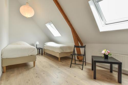 a attic room with a bed and a chair and skylights at Royaal appartement in het centrum van Yerseke in Yerseke