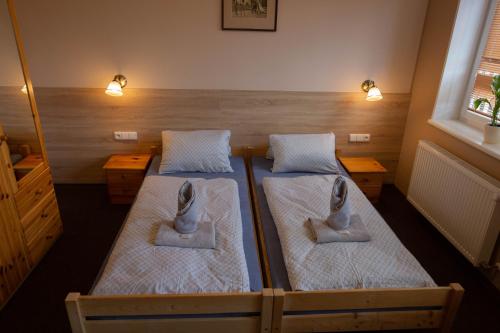 a room with two beds and two lights on the wall at Penzion Štekrův Mlýn in Františkovy Lázně
