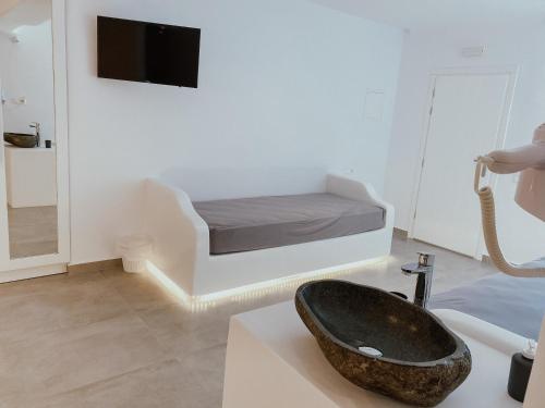 a bathroom with a sink and a bed in a room at Eternal Suites in Mýkonos City