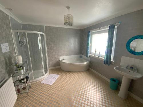 un bagno con vasca e lavandino di Dunrigh Guest House a Oban