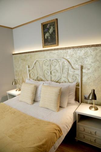a bedroom with a large bed with white pillows at Vintage Apartment - Ultracentral, 2 dormitoare in Sighişoara