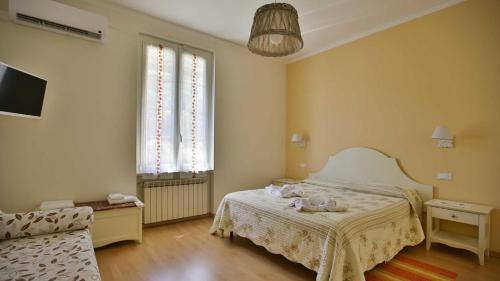 a bedroom with a bed and a couch and a tv at Ca Lorelei in Riomaggiore