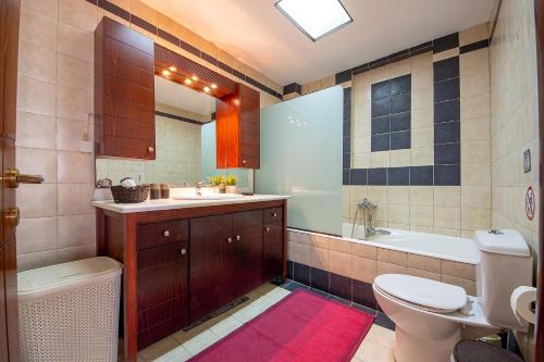 a bathroom with a toilet and a sink and a tub at MariZot Apartment in Alexandroupoli
