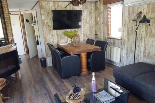 a living room with a table and a couch at Stuyvesanthof scheldeoord chalet 710 in Baarland