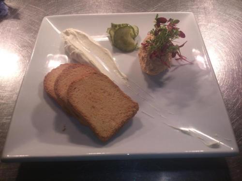 a white plate with a piece of bread and a sandwich at The Moorland Hotel in Wotter