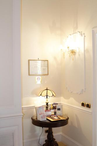 a room with a table with a lamp on it at Hotel Villa Pinciana in Rome