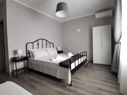 a white bedroom with a bed and a lamp at B&B TrentaQuattro in Campomarino