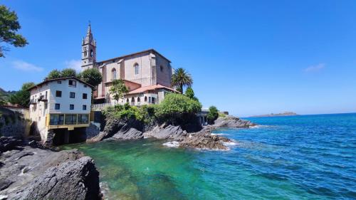 um grupo de edifícios ao lado de uma massa de água em Mundaka Sea Flat em Mundaka