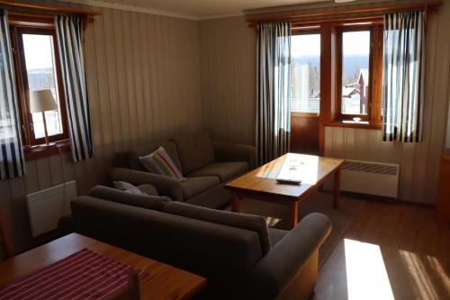 a living room with two couches and a table at Fjällriket Baggården in Baggården