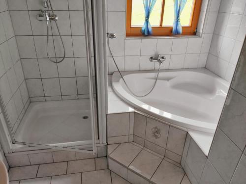 La salle de bains est pourvue d'une douche, d'une baignoire et d'un lavabo. dans l'établissement Gästehaus Laßnig, à Ebene Reichenau
