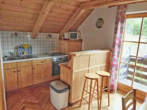 a kitchen with wooden cabinets and a sink and a stove at Gästehaus Laßnig in Ebene Reichenau