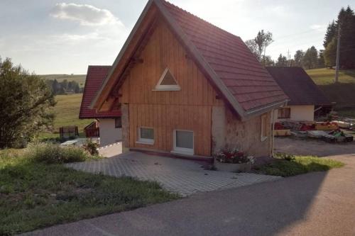 una pequeña casa con techo rojo en Mühlehof en Herrischried