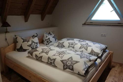 a bed with black and white blankets and pillows at Mühlehof in Herrischried