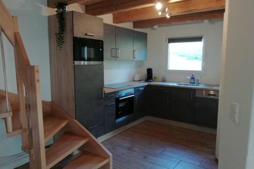 a kitchen with black cabinets and a sink at Mühlehof in Herrischried