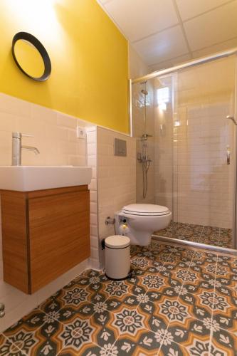 a bathroom with a toilet and a sink and a shower at Holy Pansiyon in Kaş