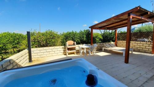 bañera en un patio con mesa y sillas en Residence Del Tellaro en Noto Marina
