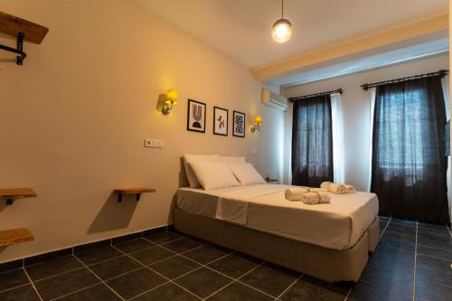 a bedroom with a bed and two windows at Holy Pansiyon in Kaş