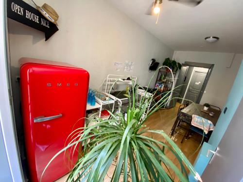 a room with a red refrigerator and a potted plant at Open House #hostel in Nice