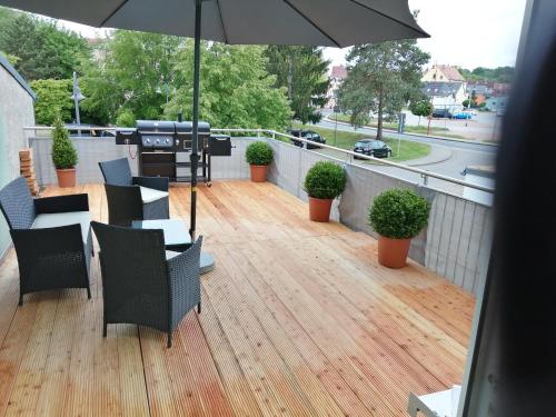 eine Terrasse mit einem Tisch, Stühlen und einem Sonnenschirm in der Unterkunft KIC Kochschule in Colditz Gastroverleih, Mietkoch, HMDL, FEWO in Colditz