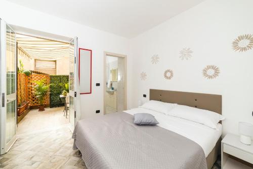 sypialnia z dużym białym łóżkiem i drzwiami w obiekcie Bell'Albenga w Albendze
