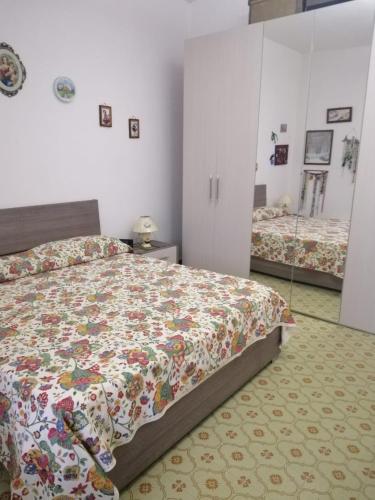 1 dormitorio con 1 cama con edredón de flores en Sole & luna en Perdaxius