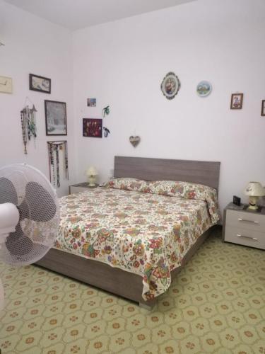ein Schlafzimmer mit einem Bett mit einer Bettdecke in der Unterkunft Sole & luna in Perdaxius